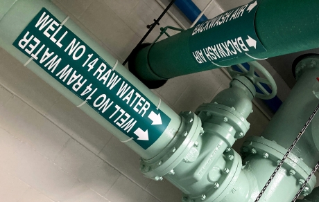 large pipes painted green and labeled Well No. 14 Raw Water